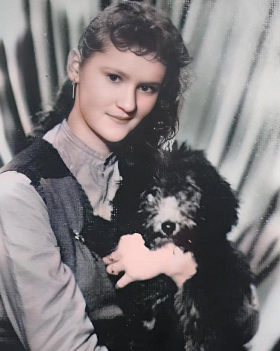 Historisches Foto: junge Frau mit einem schwarzen Pudel auf dem Arm