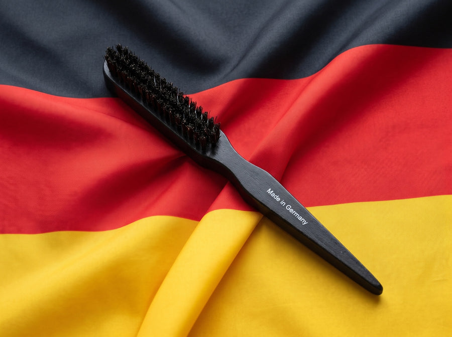 Schwarze Wildschweinborsten-Bürste mit Gravur Made in Germany auf einer Deutschlandfahne